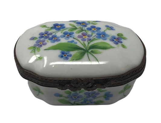 Whimsical Blooms: White Oval Limoges Box with Blue Flower Bouquet